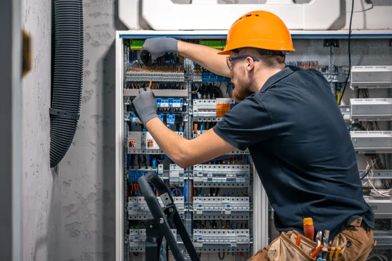 guy in yellow hardhat working on electrical panel